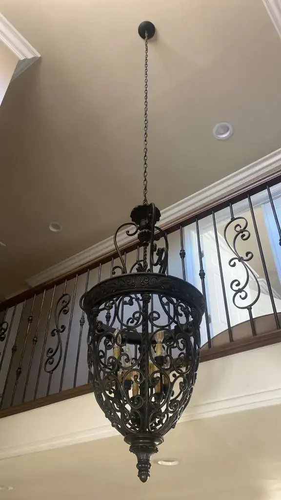 Wrought-iron pendant light fixture installed above a residential staircase by AM Electrical